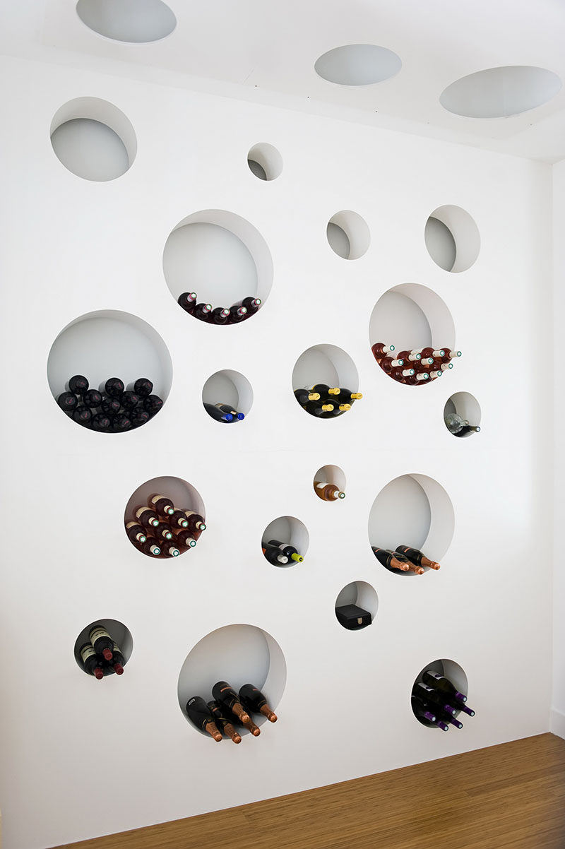 This cellar features a wall with circular cut outs to store the wine bottles.