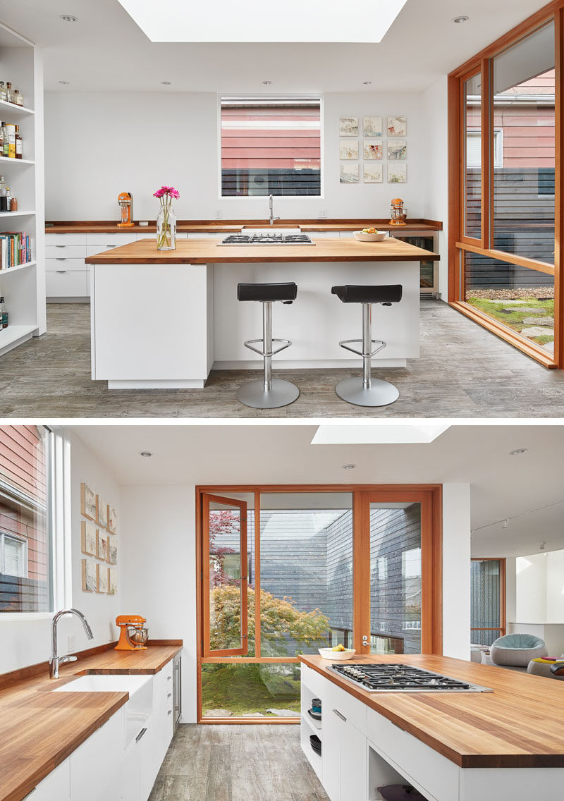 In this custom designed kitchen, white walls and cabinetry have been paired with walnut countertops.