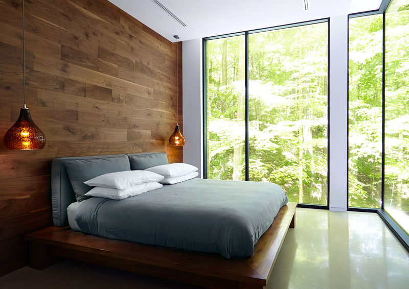 This bedroom has a feature wall and bedframe made from wood.