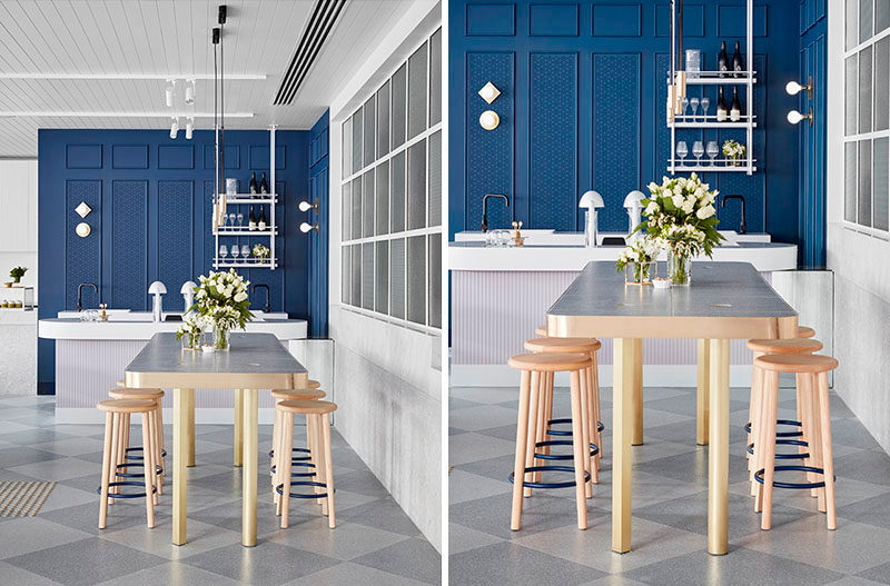 There's plenty of seating in this contemporary cafe, like this tall table that's surrounded by stools and has a metallic trim.