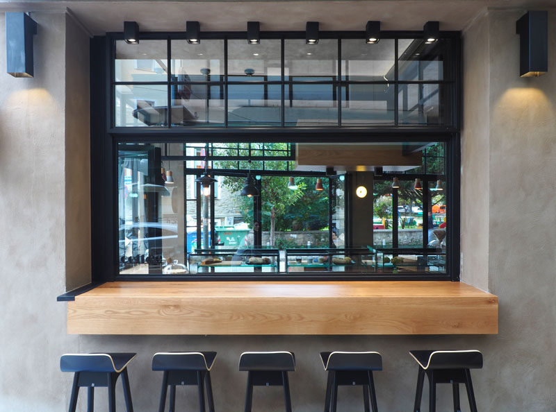 This modern cafe has a serving bar with stools that allows guests to sit outside.