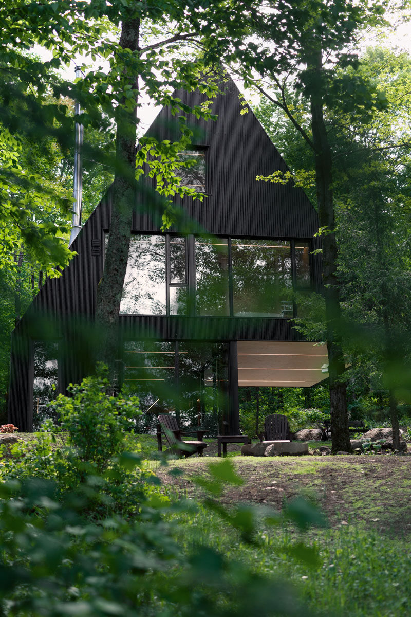 18 Modern House In The Forest // This black cabin is a summer home surrounded by a Hemlock forest in eastern Canada. #ModernHouse #ModernArchitecture #HouseInForest #HouseDesign