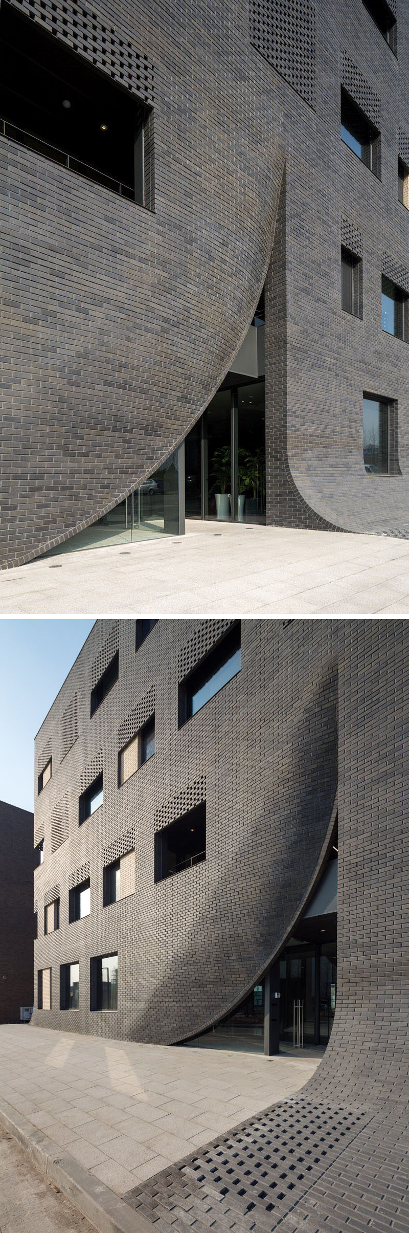 This black brick building in Korea has sections of curved brickwork that expose the entrances, and also curve down to meet the sidewalk.