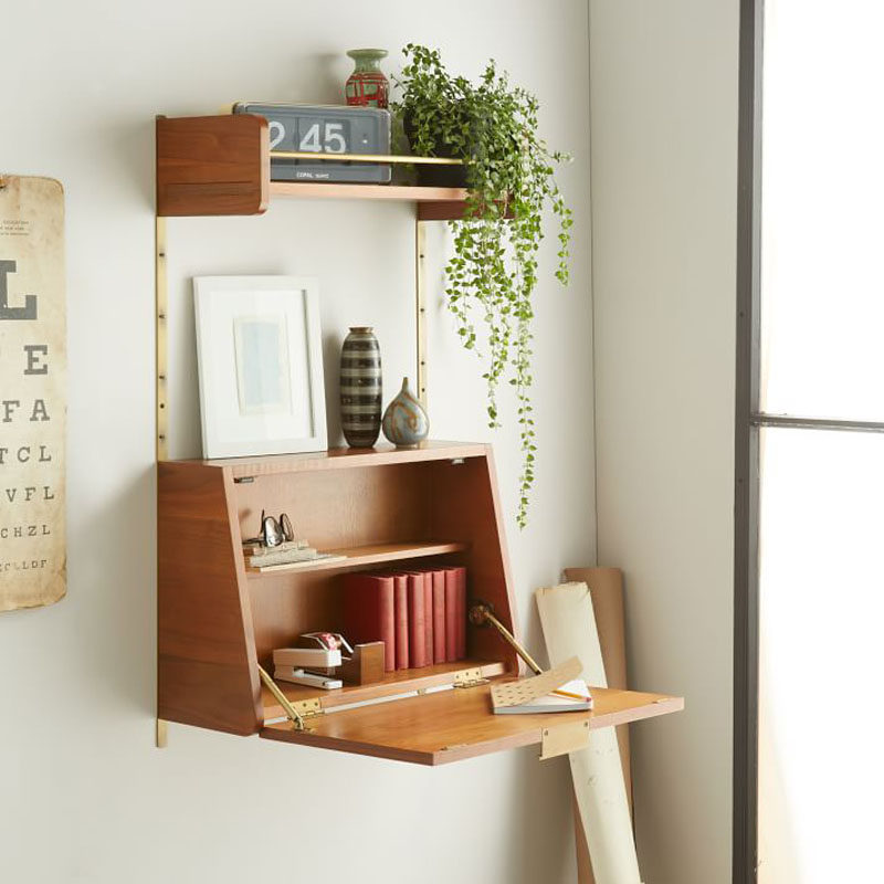 The door of this wall shelving unit opens up to become the perfect writing surface that can also hide things when you close it up.