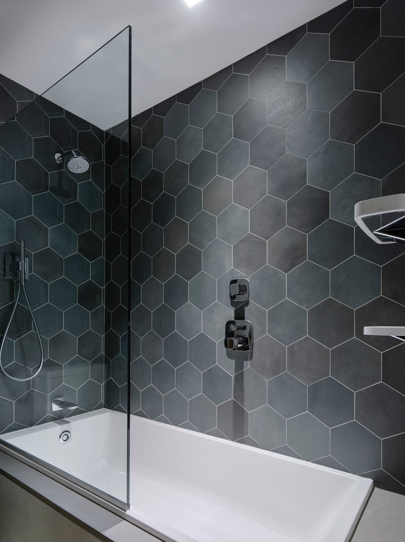 Bathroom Tile Ideas - Grey Hexagon Tiles // Hexagon tiles in various shades of grey line the walls in the 2-in-1 bath and shower in this bathroom.