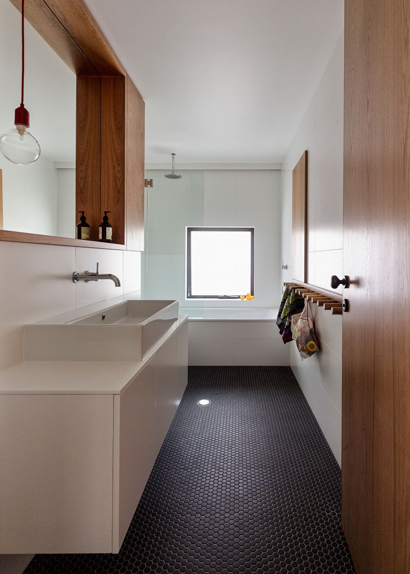 Bathroom Tile Ideas - Grey Hexagon Tiles // Dark grey hexagonal penny tiles cover the floor of this bathroom, contrasting the white and wood and adding a modern touch to the bright space.