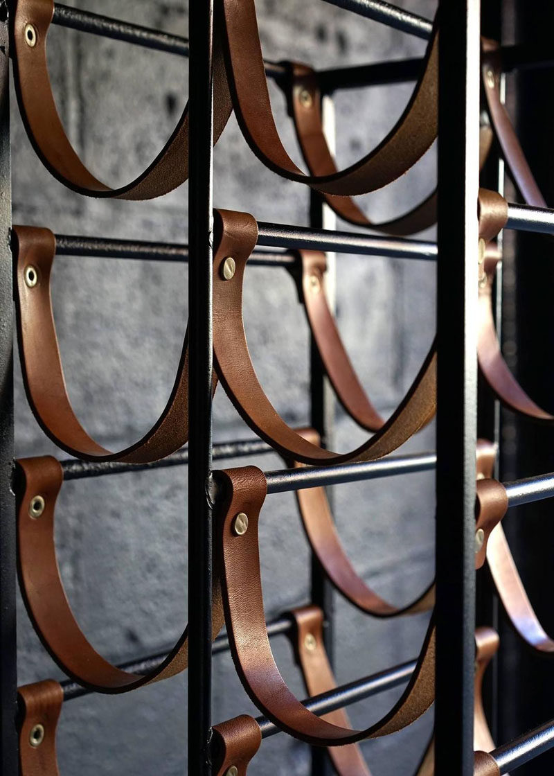 Interior Design Details - Industrial Close Ups // Dark metal, leather strips, and brass hardware make this wine rack the perfect modern industrial accent piece.