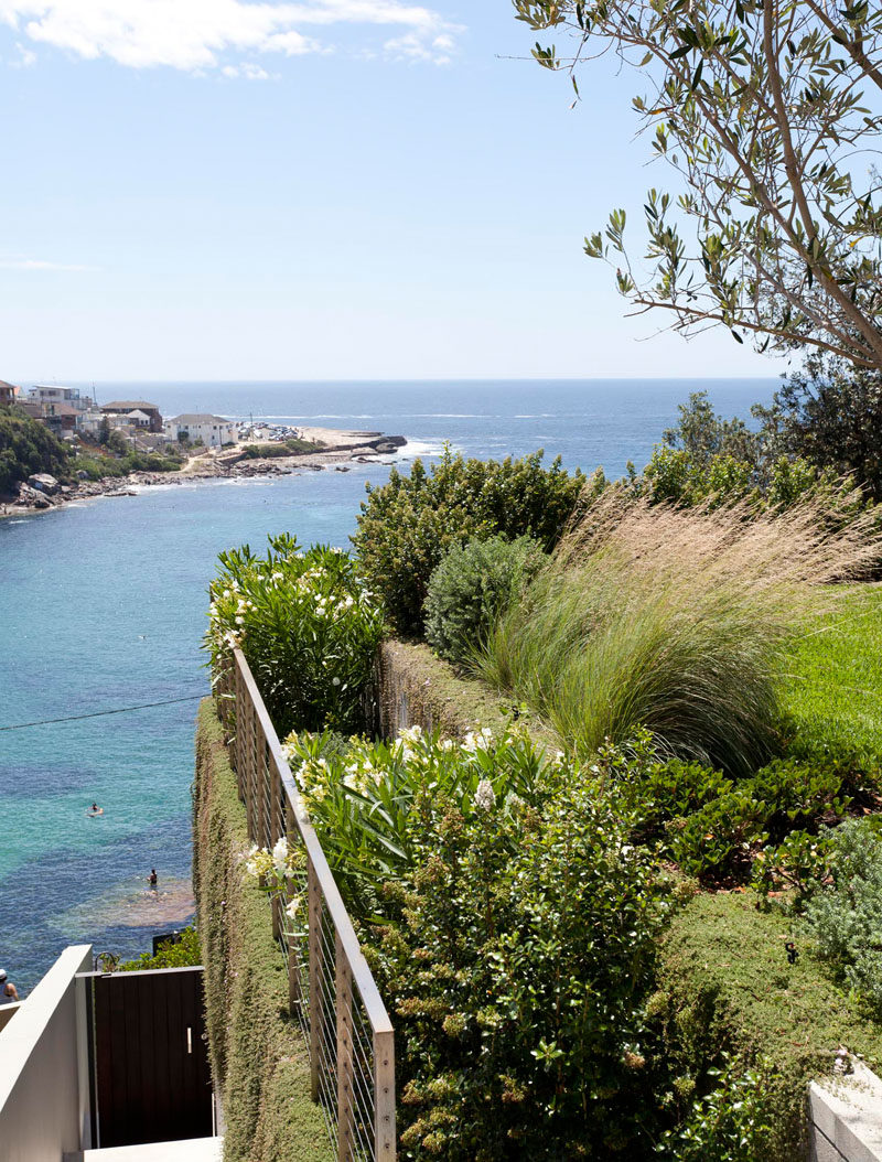 At the side of this landscaped backyard there are steps that lead down to the beach.