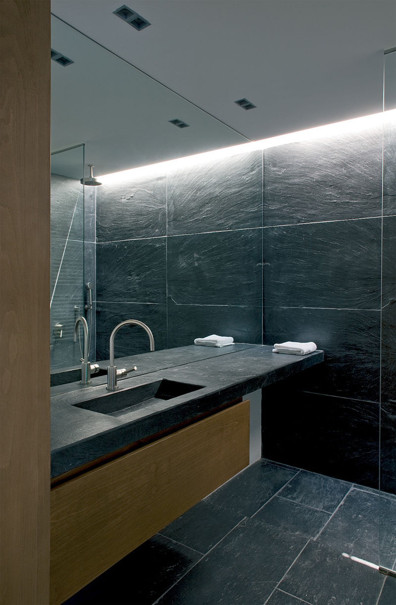 Bathroom Mirror Ideas - Fill The Wall // This full wall mirror starts at the level of the vanity and continues all the way up to the ceiling of this stone tile clad bathroom.