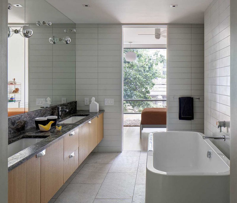 Bathroom Mirror Ideas - Fill The Wall // The light fixtures in this bathroom are built right into this mirror that takes up the entire wall above the vanity.