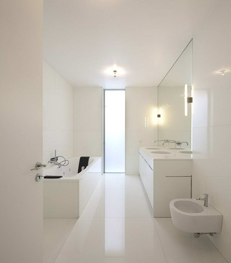 Bathroom Mirror Ideas - Fill The Wall // The mirror in this bathroom perfectly matches up with the double vanity beneath it and has the faucets coming out of it to create a seamless and continuous look.