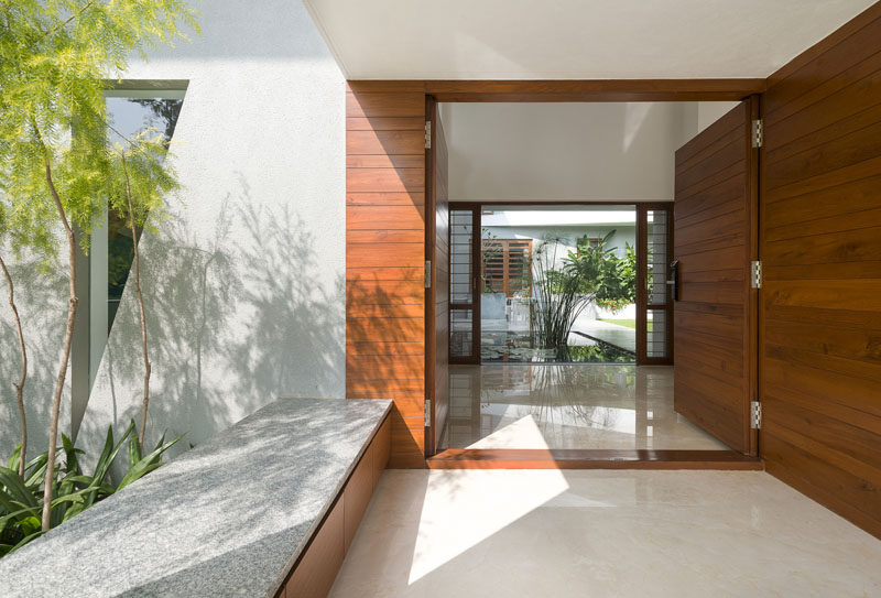 Large wooden doors and a built-in bench welcome you to this home and give you a glimpse of the backyard.