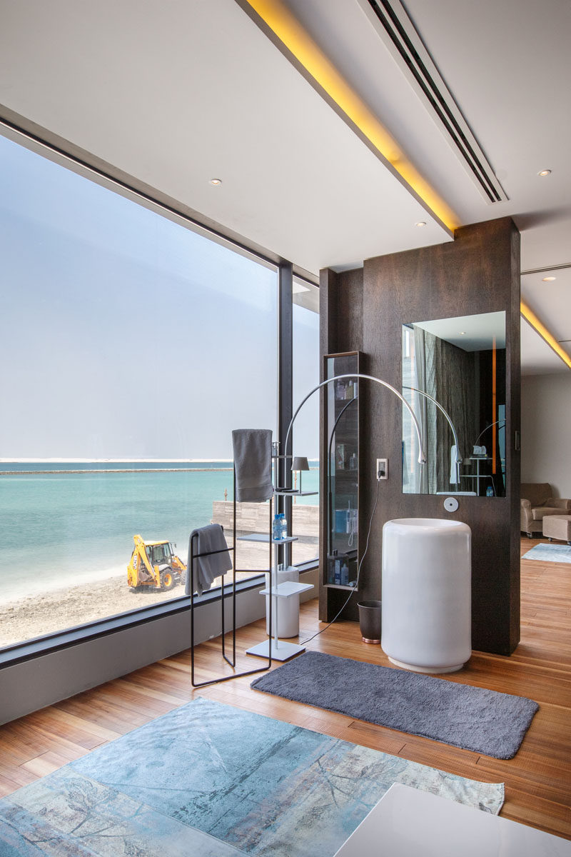 This master bathroom makes the most of the views through the large windows, and hidden lighting runs the length of the ceiling. #Bathroom #HiddenLighting