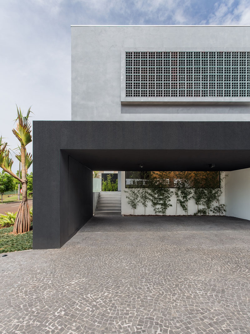 Located at the side of this house is a covered carport that's large enough to accommodate three cars, and also provides access to the home via a set of stairs.