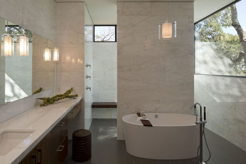 In this modern bathroom, there's a deep soaking tub and a large walk-in shower. Windows in the upper part of the walls provide light and at the same time privacy.