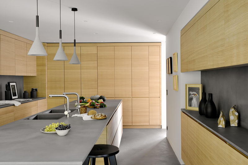 This kitchen has been designed with floor-to-ceiling wooden cabinetry and a large island with space for casual stool seating.