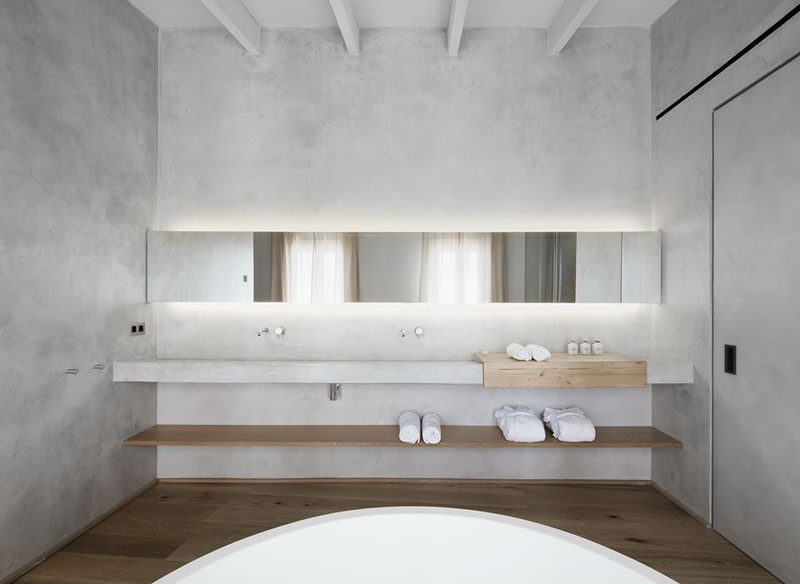 Bathroom Design Ideas - Open Shelf Below The Countertop // The long wood self under the counter of this minimalist bathroom creates a place to store bathroom supplies and adds an element of depth to the space.