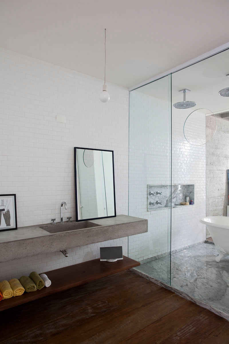 Bathroom Design Ideas - Open Shelf Below The Countertop // The wooden shelf under the concrete countertop provides a dry place to keep things you don't want getting wet, like towels and speakers.