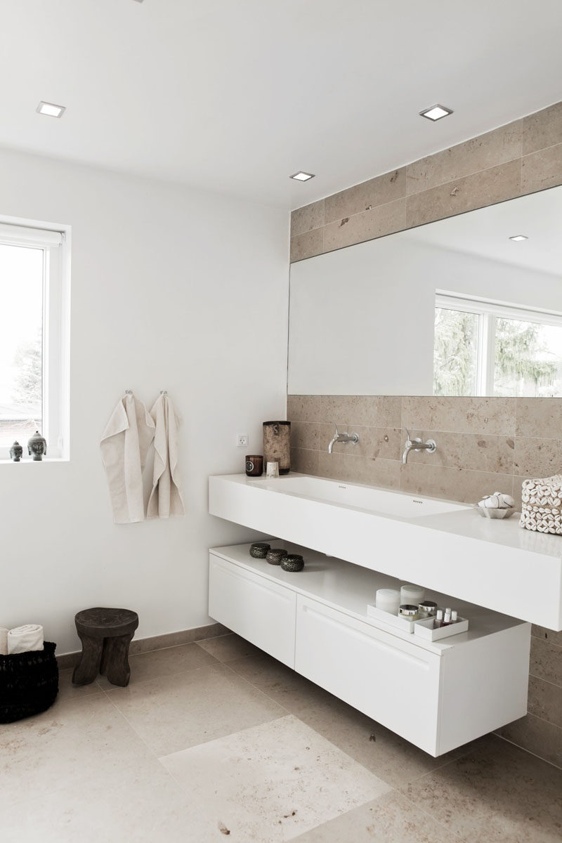 Bathroom Design Ideas - Open Shelf Below The Countertop // The shelf under the sink doesn't have to run the full length of the counter, as seen in this bright bathroom. Leaving a bit of space between the end of the shelf and the end of the counter creates the perfect spot for either a trash can or a laundry basket.