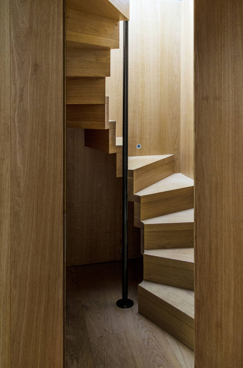 13 Stair Design Ideas For Small Spaces // These compact wooden stairs spiral up around a black pole that you can hang onto as you climb up and down for a bit of extra safety and support.