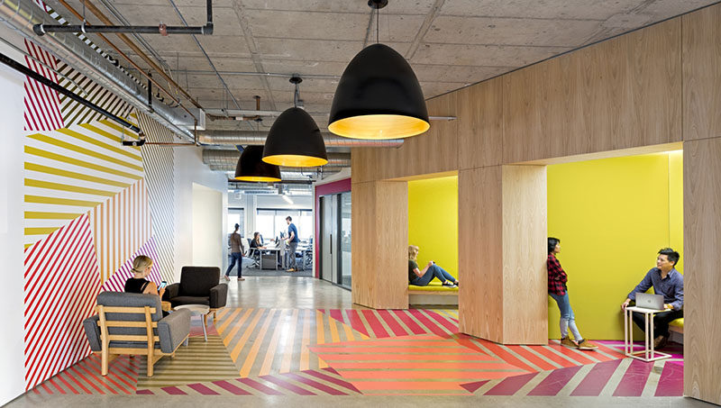 Interior Design Idea - This office design has a colorful geometric pattern that flows from the wall to the floor, and is inspired by the colors of the tulip fields in the Netherlands.