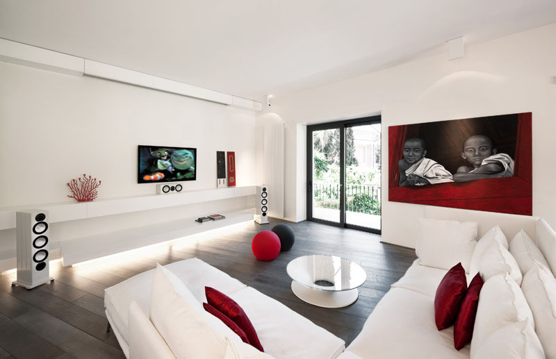 8 TV Wall Design Ideas For Your Living Room // The TV and the sound system in this white and red themed living room are surrounded by very little else and to make them the main focus in the room.