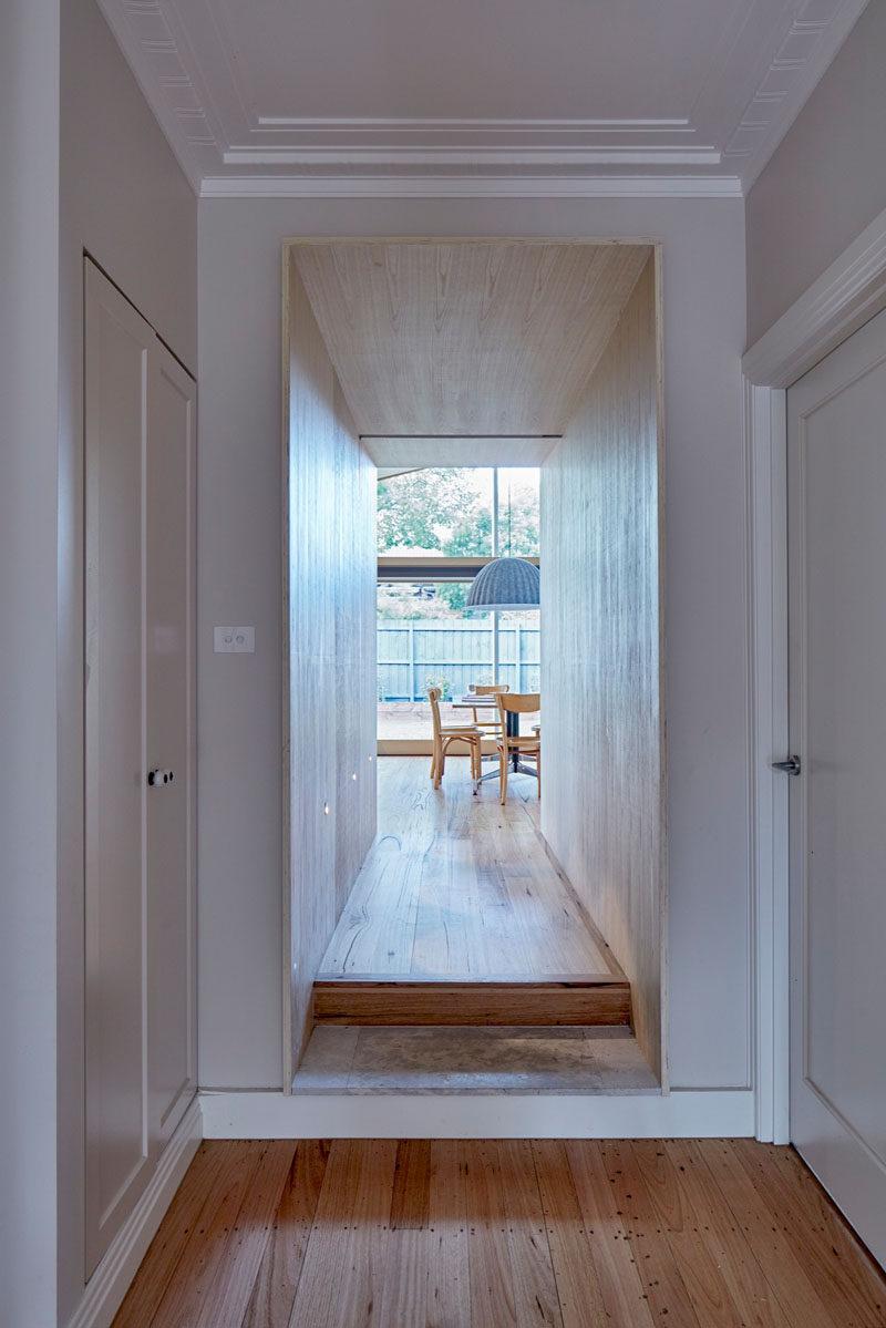 This wood covered hallway defines the entrance to the extension that was added to this Australian home.
