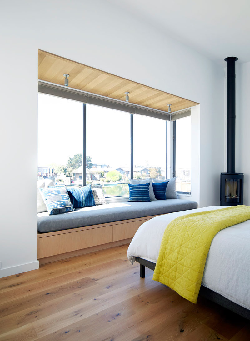 In this bedroom, a built-in upholstered window seat perfectly fits the length of the window and provides the perfect reading space.