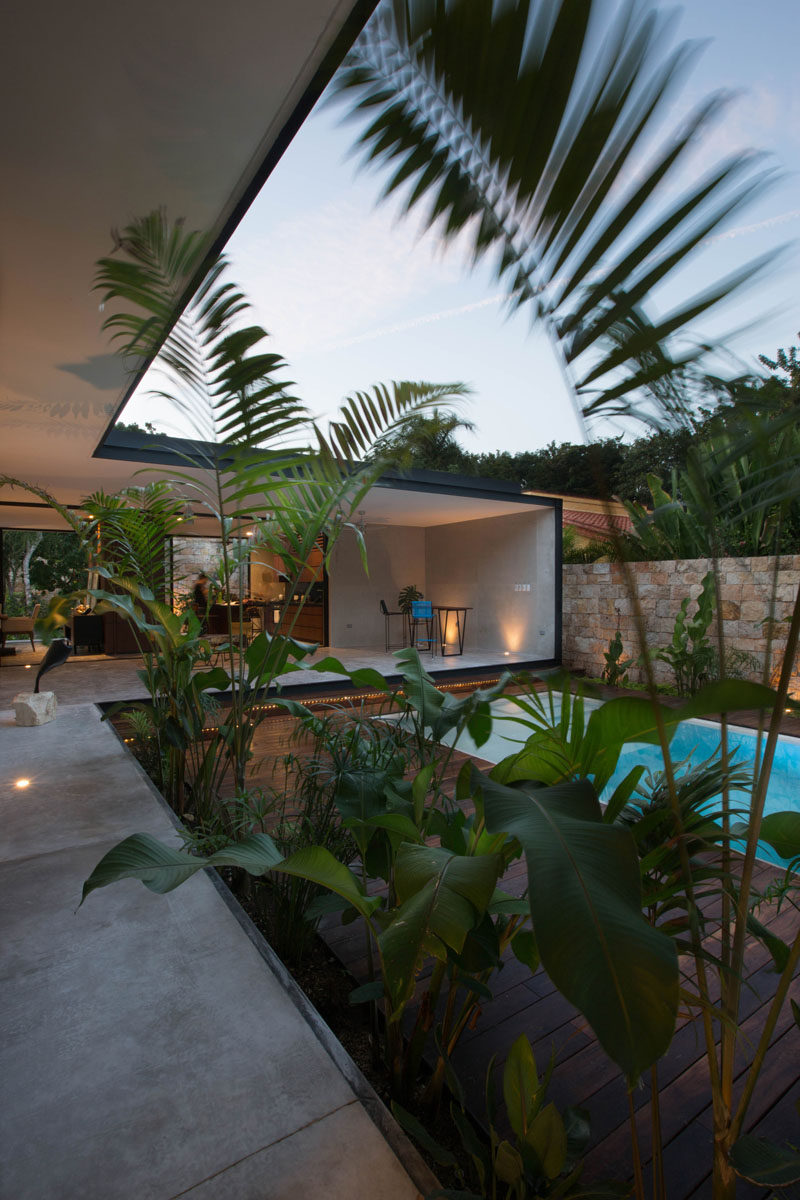 A small swimming pool in the courtyard surrounded by a wood deck and plants ties the space in with the natural feeling found throughout this home.