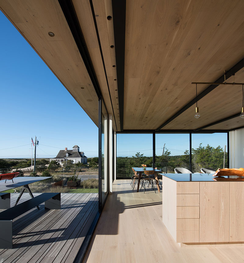 This beachside home has large windows to provide views of the surrounding neighborhood, similar to that of a lifesaving station.