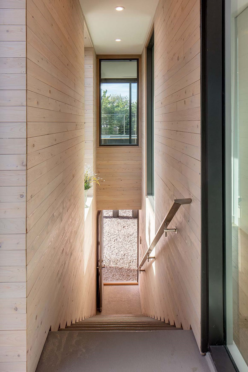 This family home was created to fit into the surrounding beach environment with a light wood exterior and black details.