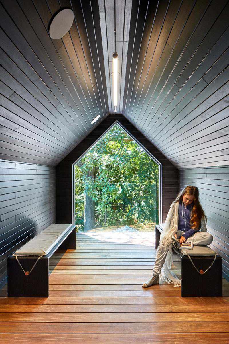 A small wood-lined room has been added into the gable of this contemporary house extension and provides a quiet retreat on the third floor of the home. 