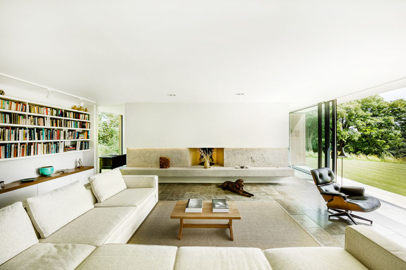 A simple neutral color palette fills this living room. The flooring is Purbeck stone, while the fireplace hearth is made from concrete.