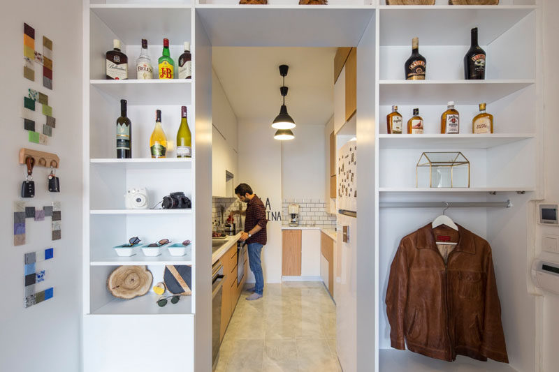 Open shelving surrounds the entrance to this kitchen and provides a place to hang jackets next to the front door.