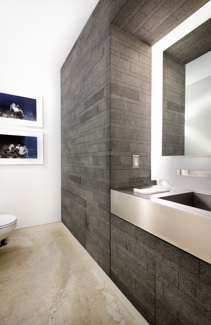 This bathroom has hidden cabinetry and lighting that surrounds the mirror.