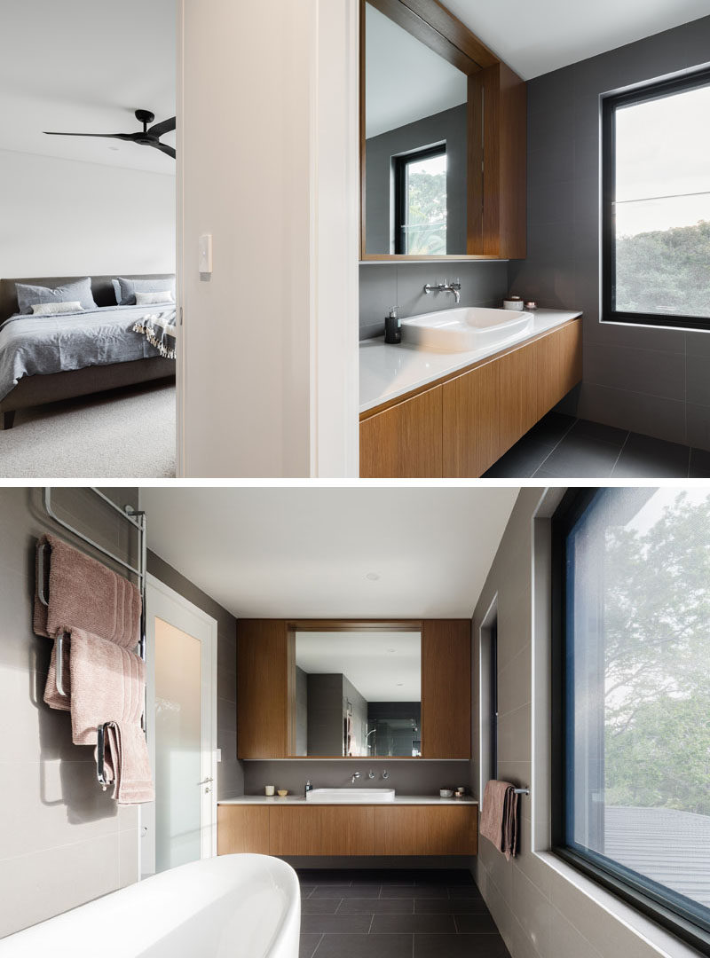 In this ensuite bathroom, a wooden vanity and mirror surround fill the wall, while leaving a space underneath to make the vanity appear as if it was floating.