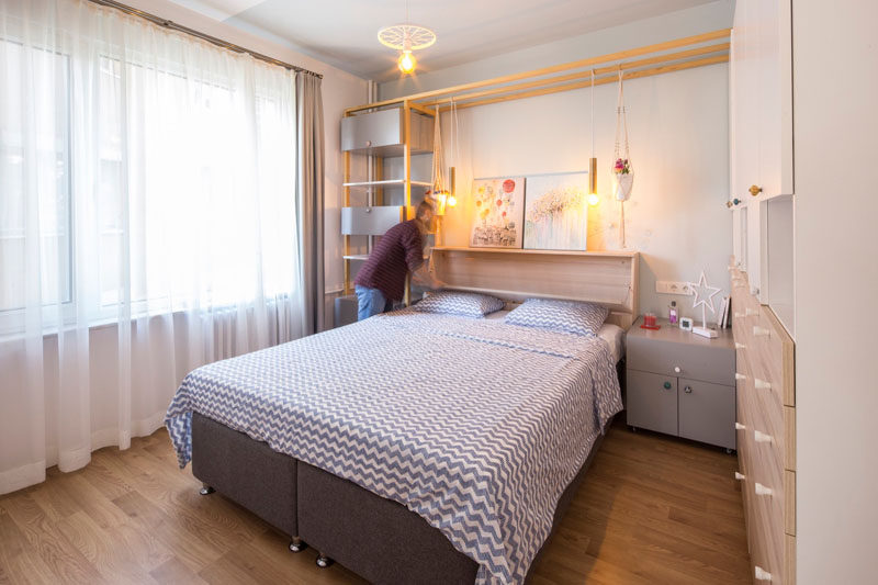 In this contemporary bedroom, shelving wraps around the bed and provides a place for lamps to be hung and decorative items to be displayed.