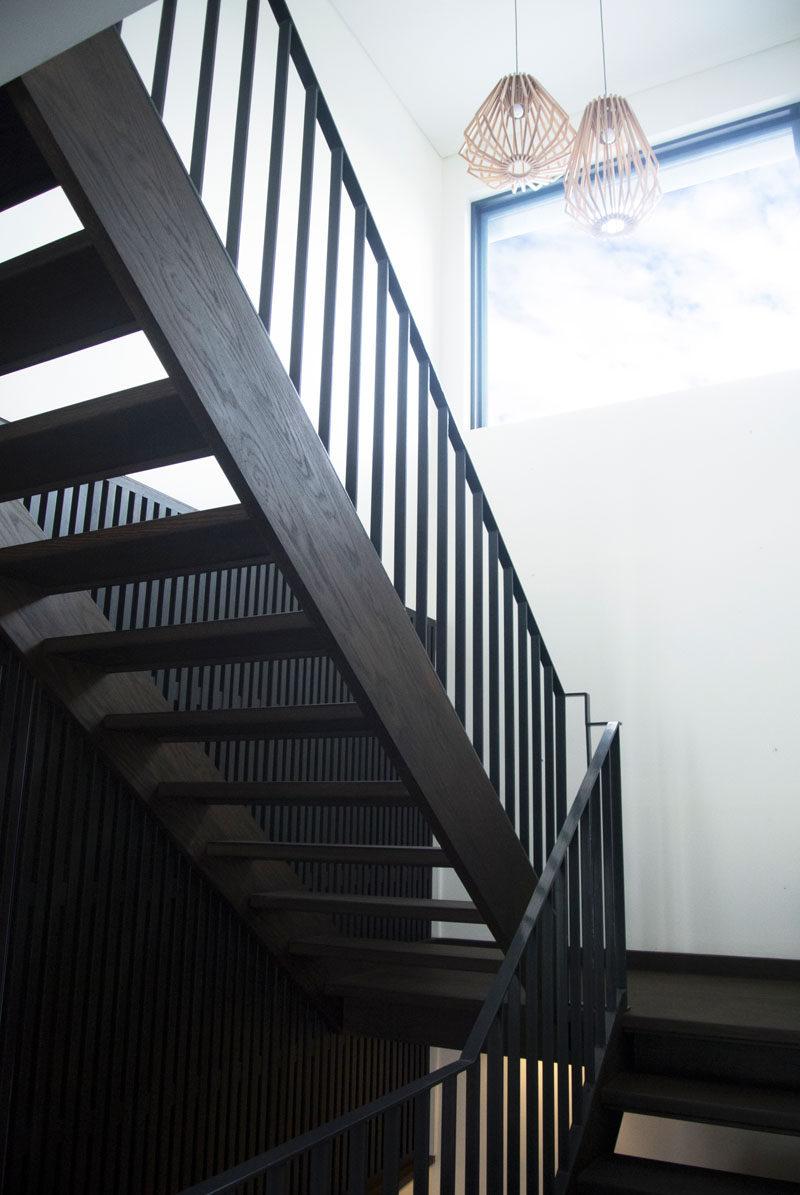 A contemporary dark wood staircase leads you upstairs and a large window floods the space with natural light.