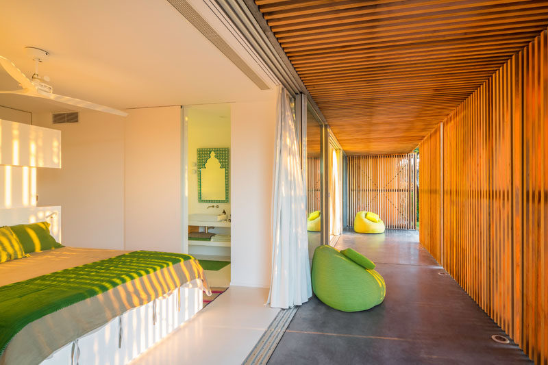 In this bedroom, there's an ensuite bathroom that features green tiles to match the accents in the bedroom.