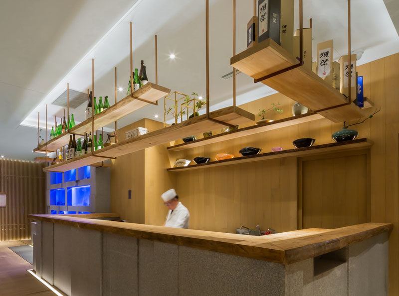 Restaurant Interior Design Ideas - This restaurant's bar has hanging wooden shelving to match the live edge wooden bar top.