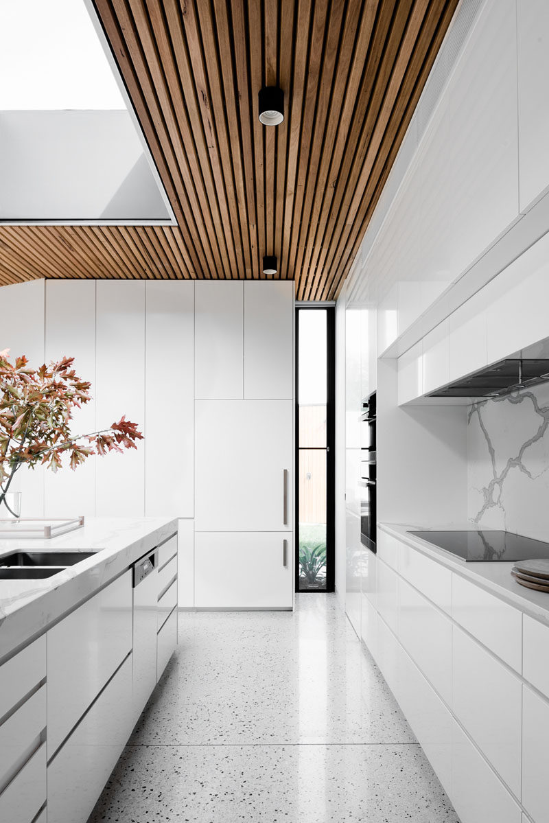 Window Style Ideas - Narrow Vertical Windows // This kitchen is already bright thanks to the all white interior but the narrow window in the corner brings in just an extra bit of light and adds some contrast with its black window frame.