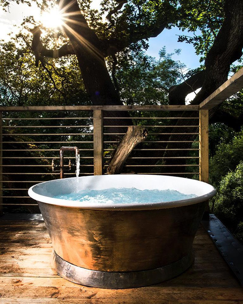 On the second storey of this grown-up treehouse, there's a large soaking tub on the rooftop deck.