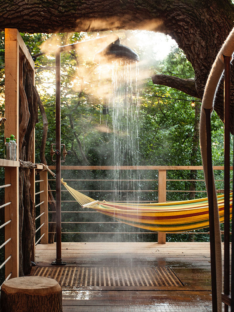 This adult treehouse has an outdoor shower that drains down to the ground below, and a hammock provides a spot to relax on a nice day.