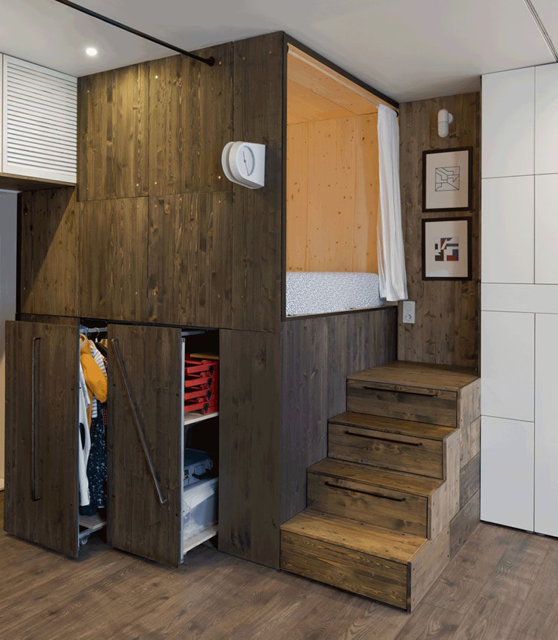 This small 376 sqft apartment has a raised bed to create additional closet space underneath, and the stairs leading to the bed have built-in storage.