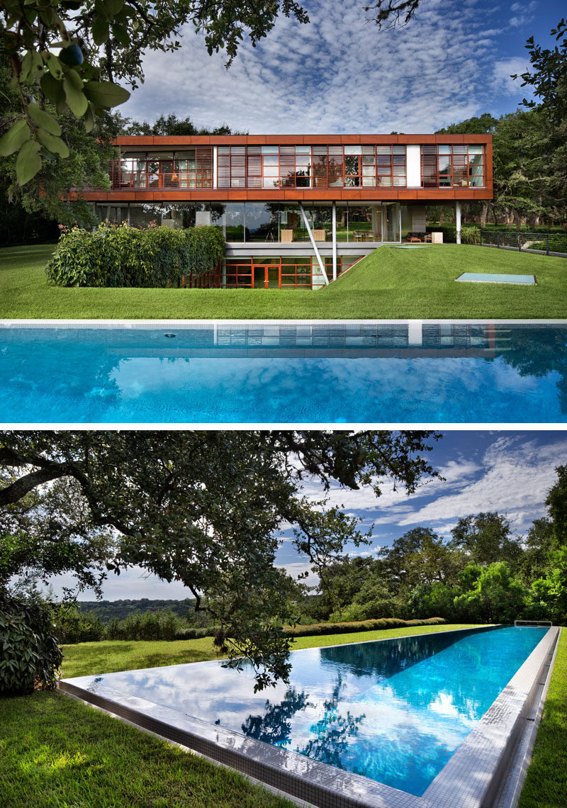 Skylights in the grass provide light to the rooms in the lower level of this modern home, and the large swimming pool is the perfect place to cool off.