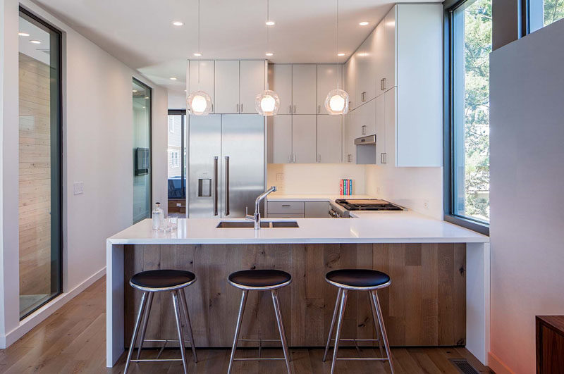 In this kitchen, the cabinets go all the way to the ceiling creating plenty of storage, and part of the countertop overhangs and provides a place for seating.