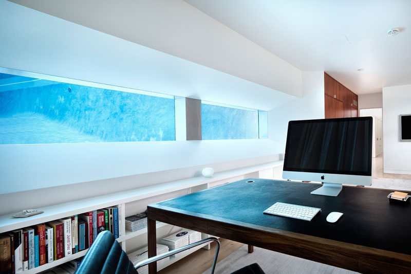 This home office is built into the ground and has a view of the pool from within the water.