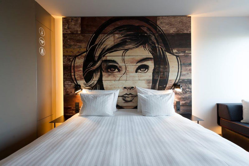 This bedroom has a mural painted on a headboard made from reclaimed wood