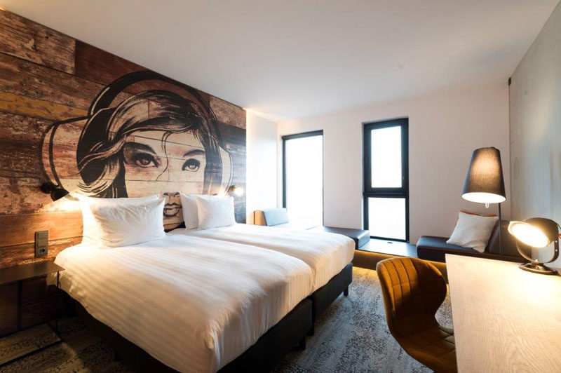 This bedroom has a mural painted on a headboard made from reclaimed wood