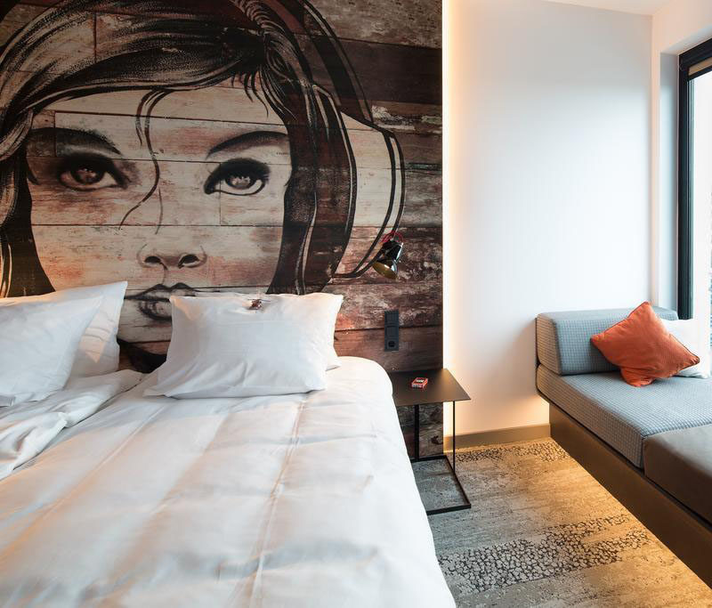 This bedroom has a mural painted on a headboard made from reclaimed wood